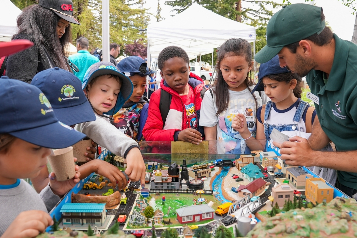 Students gathered around a watershed model at Earth Day Arbor Day